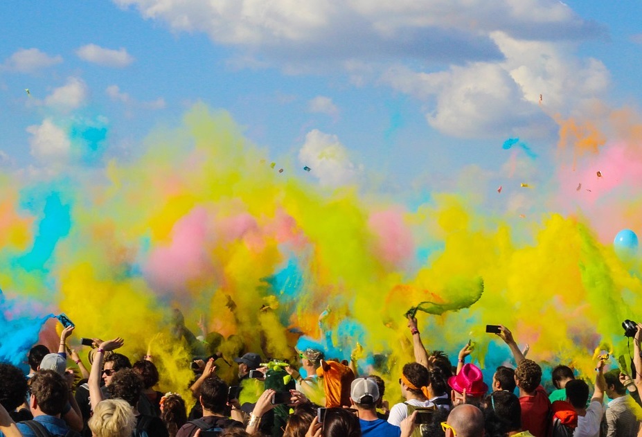 Hands throwing colour in the air at an event