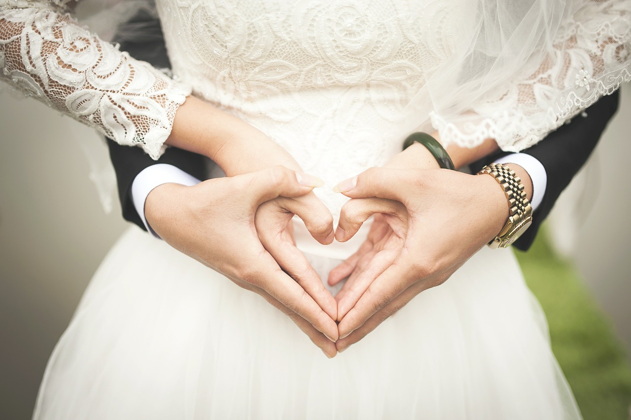 Newlyweds making a heart with their hands