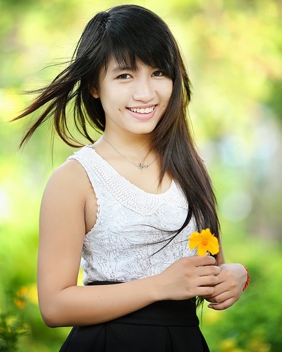 A young woman holding a flower